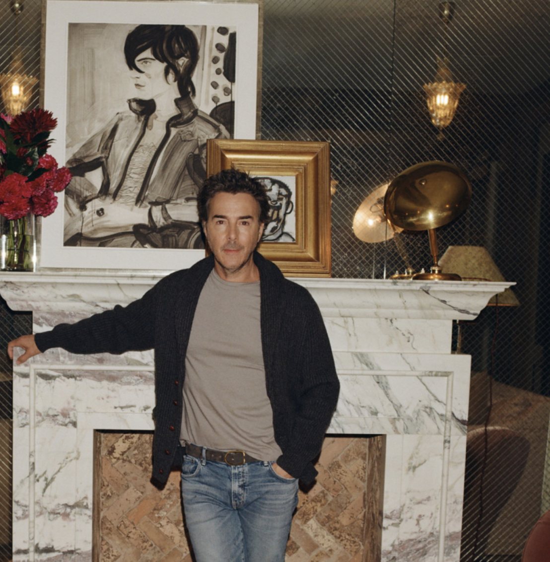 Director Shawn Levy at his Manhattan fireplace; a gold-framed Christopher Flach portrait sits on the mantel beside a work by Elizabeth Peyton, in Cultured, December 2024